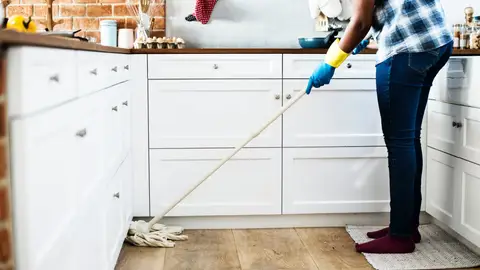Una mujer limpiando la casa