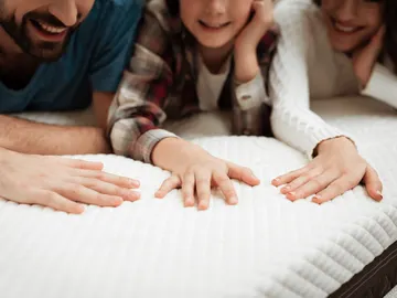 Familia en el colchón de la cama Familia en el colchón de la cama
