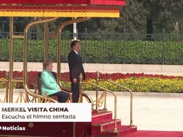 Merkel permanece sentada durante los himnos en su encuentro con el primer ministro chino