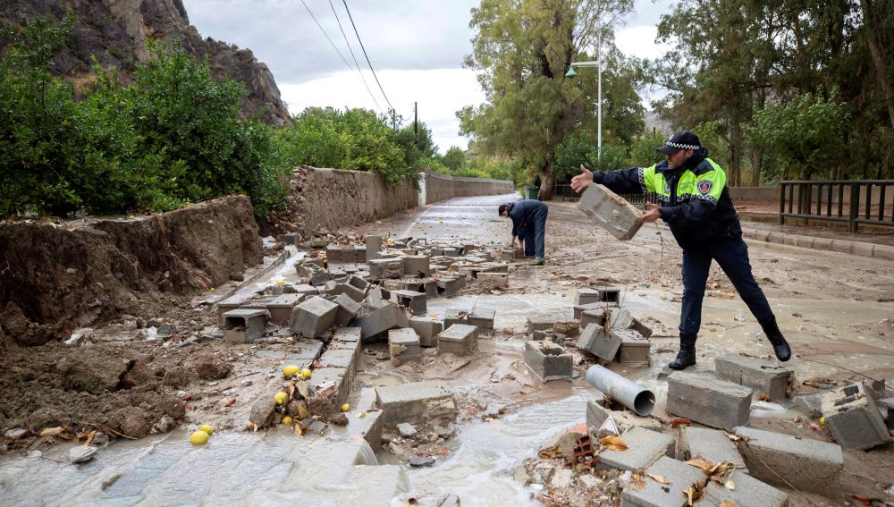 Policías locales de Blanca, Murcia, retiran los bloques de un muro derribado por las fuertes lluvias