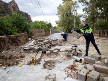 Policías locales de Blanca, Murcia, retiran los bloques de un muro derribado por las fuertes lluvias