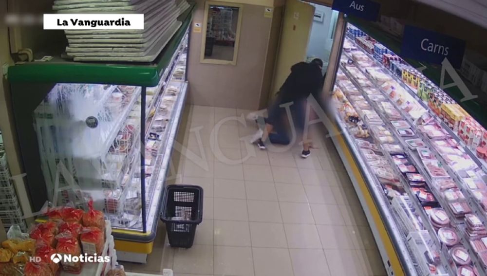 Graban el robo violento con pistola de un hombre en un supermercado de Barcelona