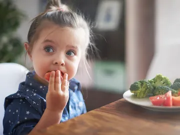 Niña comiendo vegetales Niña comiendo vegetales