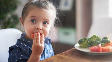 Niña comiendo vegetales