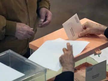 Un ciudadano deposita su voto en un colegio electoral Un ciudadano deposita su voto en un colegio electoral