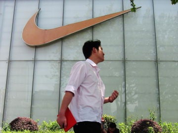 Un hombre pasa junto al letrero de una tienda Nike