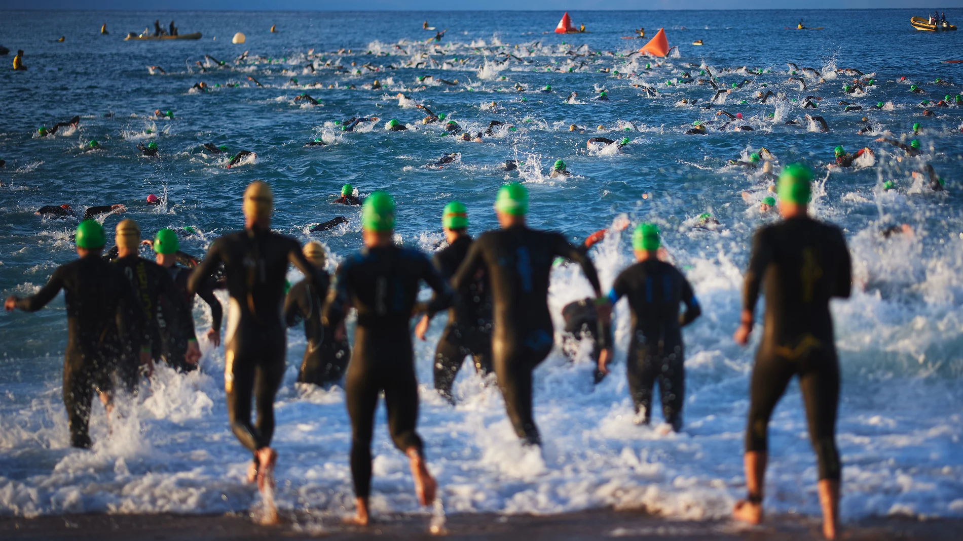 Un grupo de corredores iniciando el tramo de natación de un Ironman Un grupo de corredores iniciando el tramo de natación de un Ironman