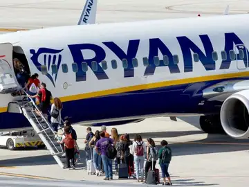 Un grupo de pasajeros hace cola para subir a un avión de Ryanair Un grupo de pasajeros hace cola para subir a un avión de Ryanair