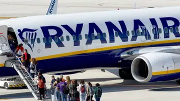 Un grupo de pasajeros hace cola para subir a un avión de Ryanair