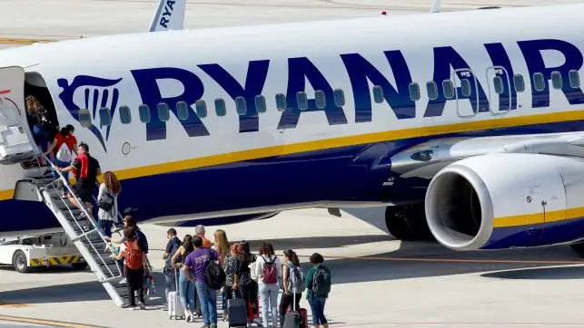 Un grupo de pasajeros hace cola para subir a un avión de Ryanair Ryanair_643x397