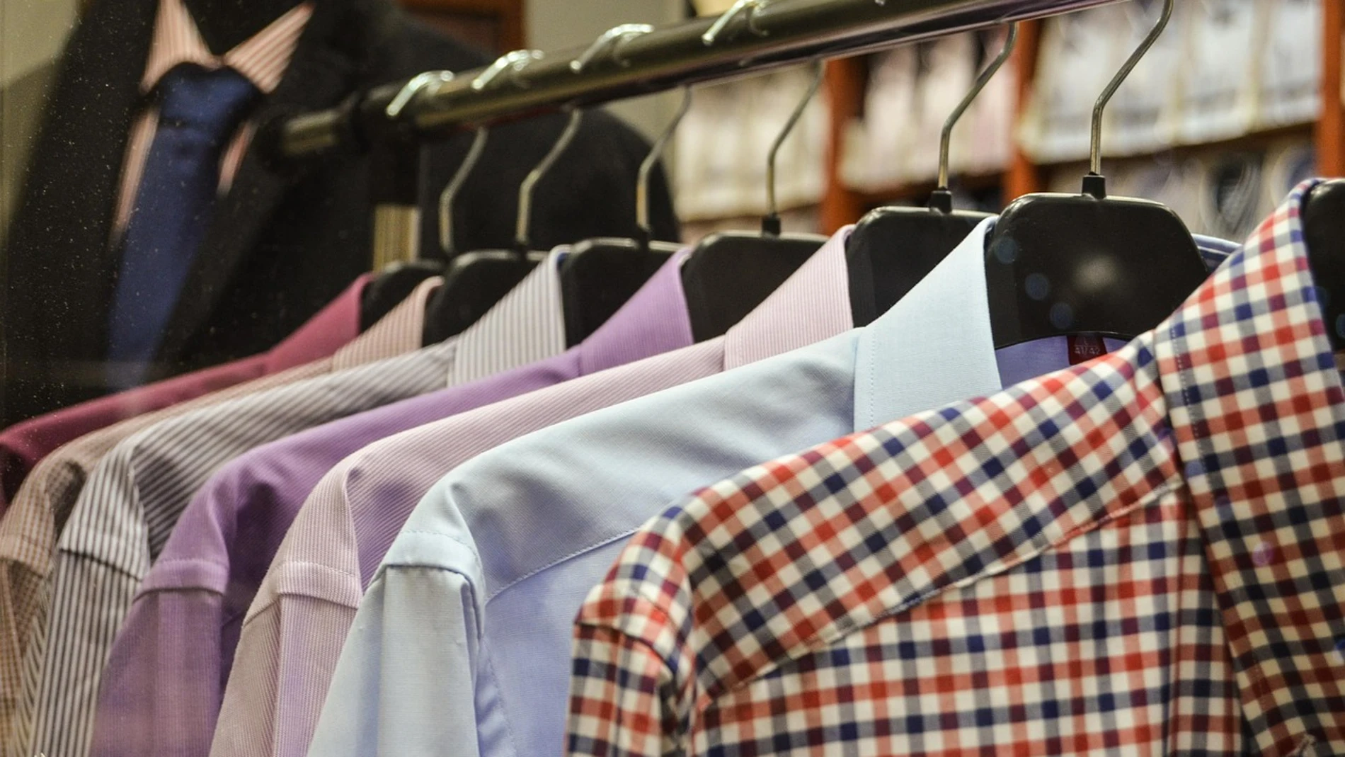 Camisas colgadas en perchas en una tienda de ropa Camisas colgadas en perchas en una tienda de ropa