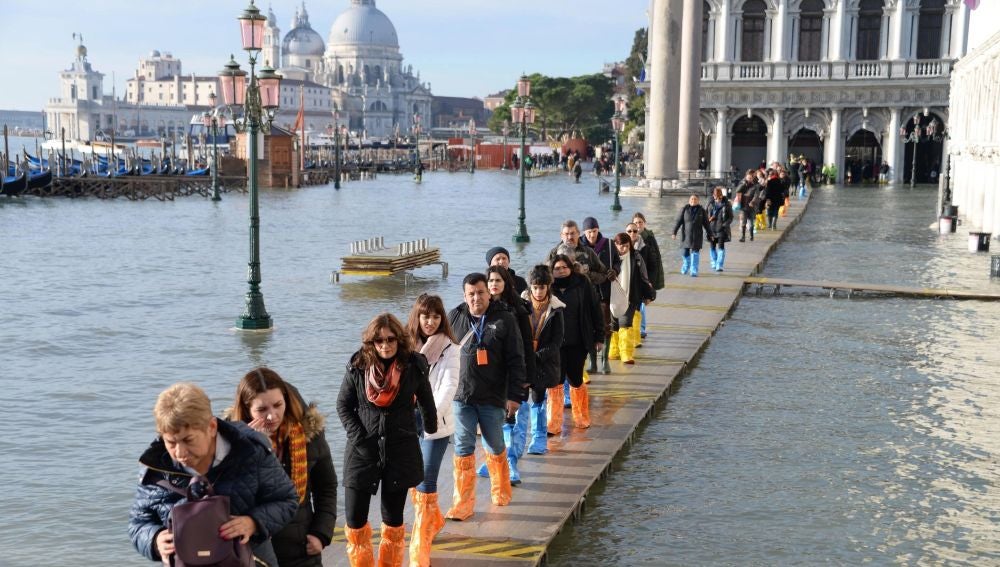 Una hilera de turistas aguarda junto al margen del río San Marco