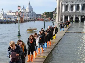 Una hilera de turistas aguarda junto al margen del río San Marco Una hilera de turistas aguarda junto al margen del río San Marco