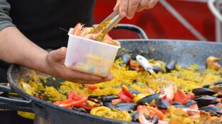 Imagen de una persona cocinando una paella