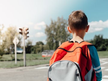 Imagen de un niño con una mochila en la calle