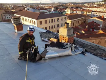 Un bombero en el tejado de un edificio Un bombero en el tejado de un edificio