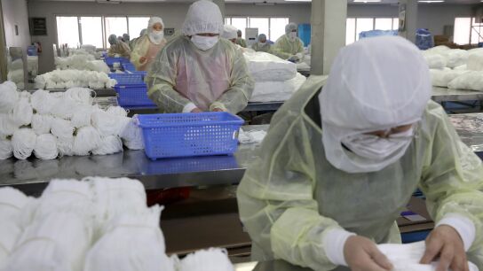 Varias personas trabajan en una f&aacute;brica de mascarillas
