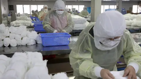 Varias personas trabajan en una fábrica de mascarillas Varias personas trabajan en una fábrica de mascarillas