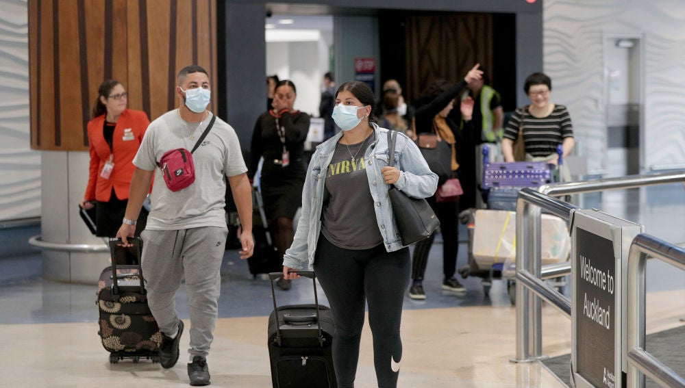 Pasajeros con máscaras en una terminal de aeropuerto