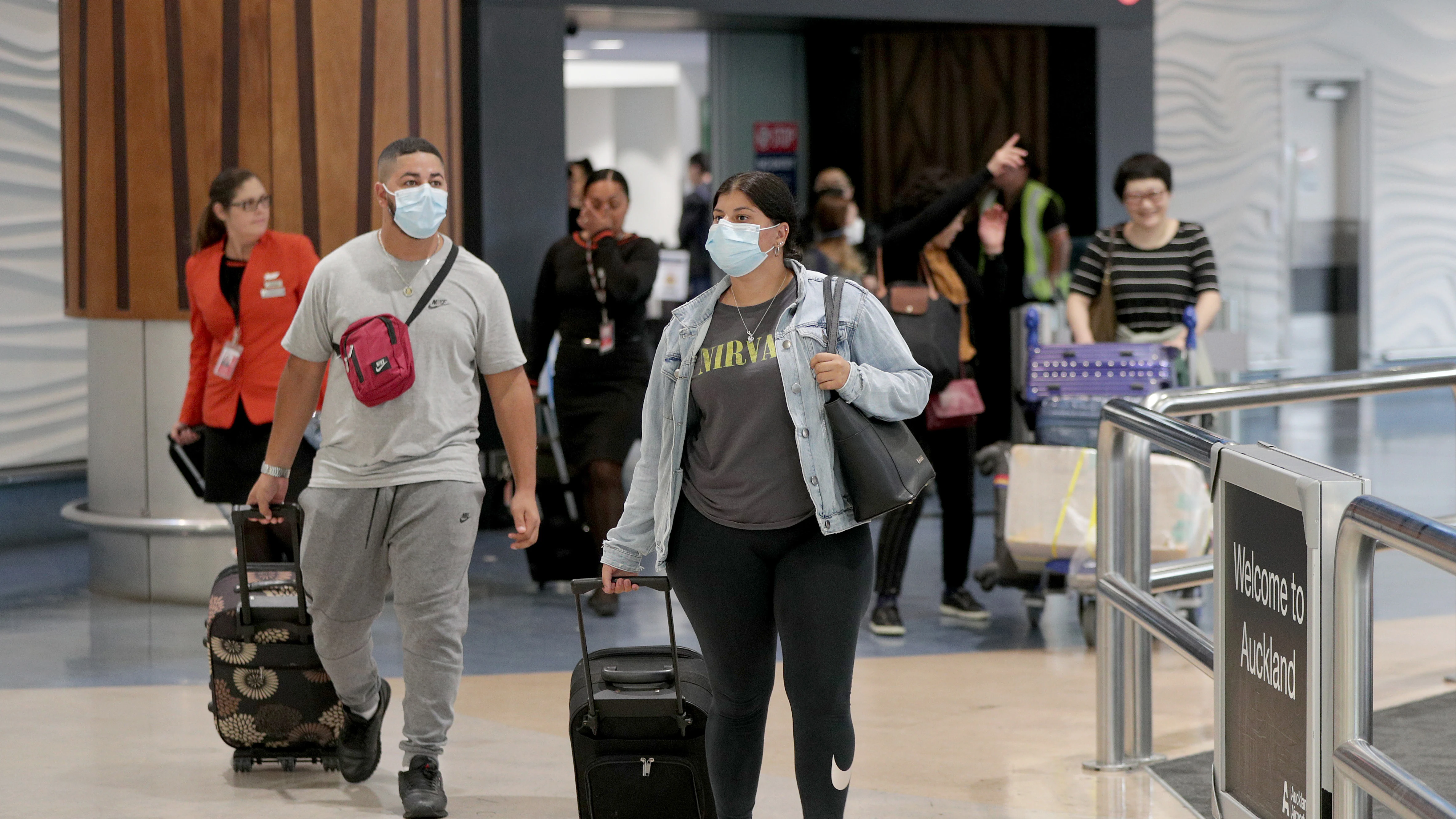 Pasajeros con máscaras en una terminal de aeropuerto Pasajeros con máscaras en una terminal de aeropuerto