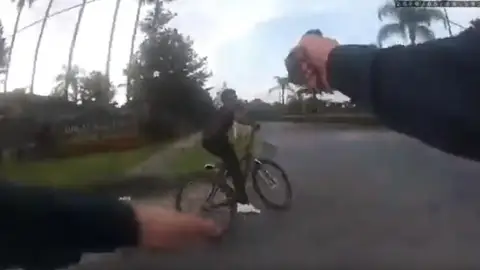 Momento en el que el agente de policía dispara contra el ciclista Momento en el que el agente de policía dispara contra el ciclista
