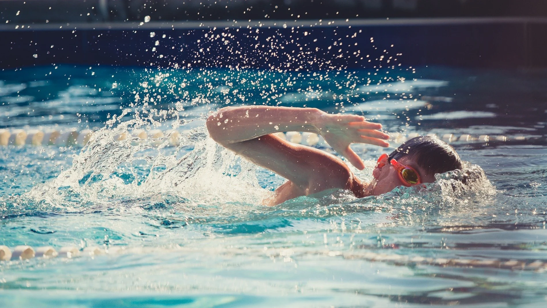 Niño entrenando en una piscina Niño entrenando en una piscina