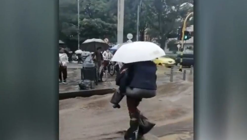 Una senadora se sube a la espalda de un hombre para cruzar la calle en Bogotá 
