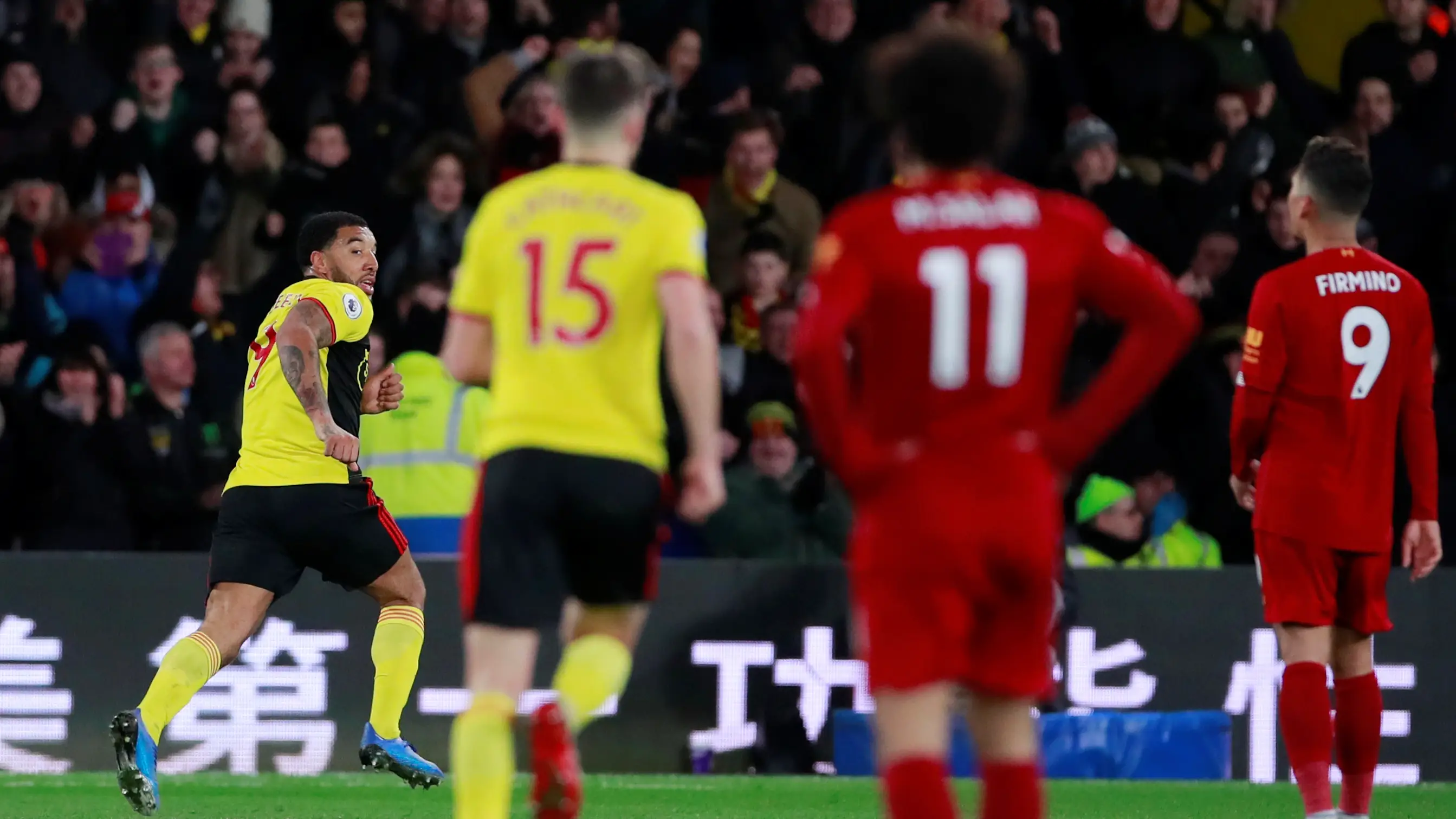 Troy Deeney celebra un gol ante Salah y Firmino Troy Deeney celebra un gol ante Salah y Firmino