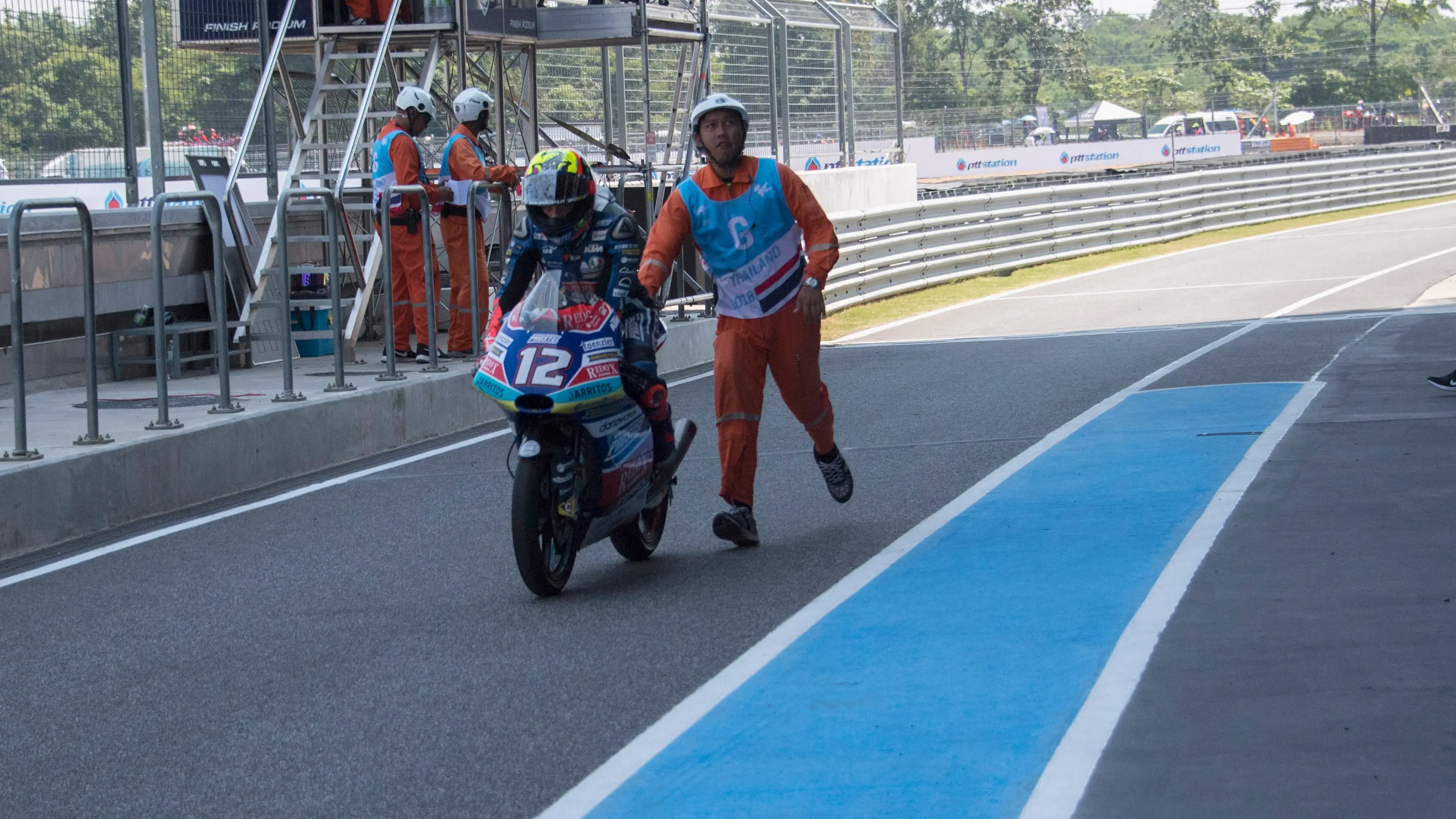 Un operario empuja a Marco Bezzecchi en el GP de Tailandia de 2018