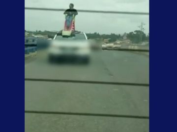 Un conductor circula con otro hombre subido en un tobogán en el techo del coche, ambos han sido detenidos