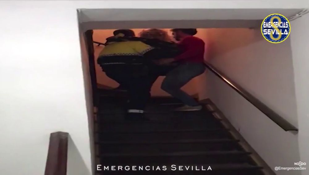 Dos policías llevan en brazos a una mujer y a su bebé recién nacido en Sevilla 