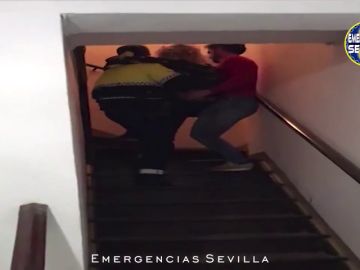 Dos policías llevan en brazos a una mujer y a su bebé recién nacido en Sevilla 