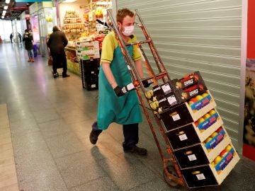 Imagen de un hombre transportando alimentos en un mercado