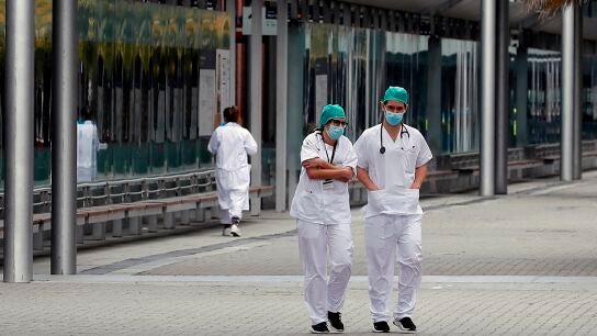 Personal sanitario descansa en los exteriores del Hospital de Ifema, este viernes en Madrid.
