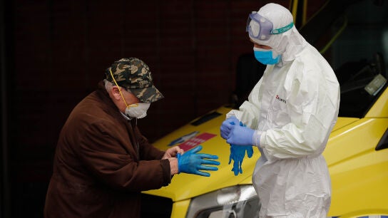 Un sanitario ayuda a un paciente