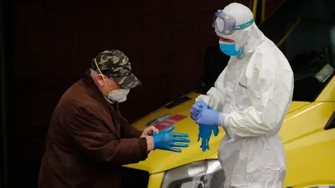 Un sanitario ayuda a un paciente Un sanitario ayuda a un paciente