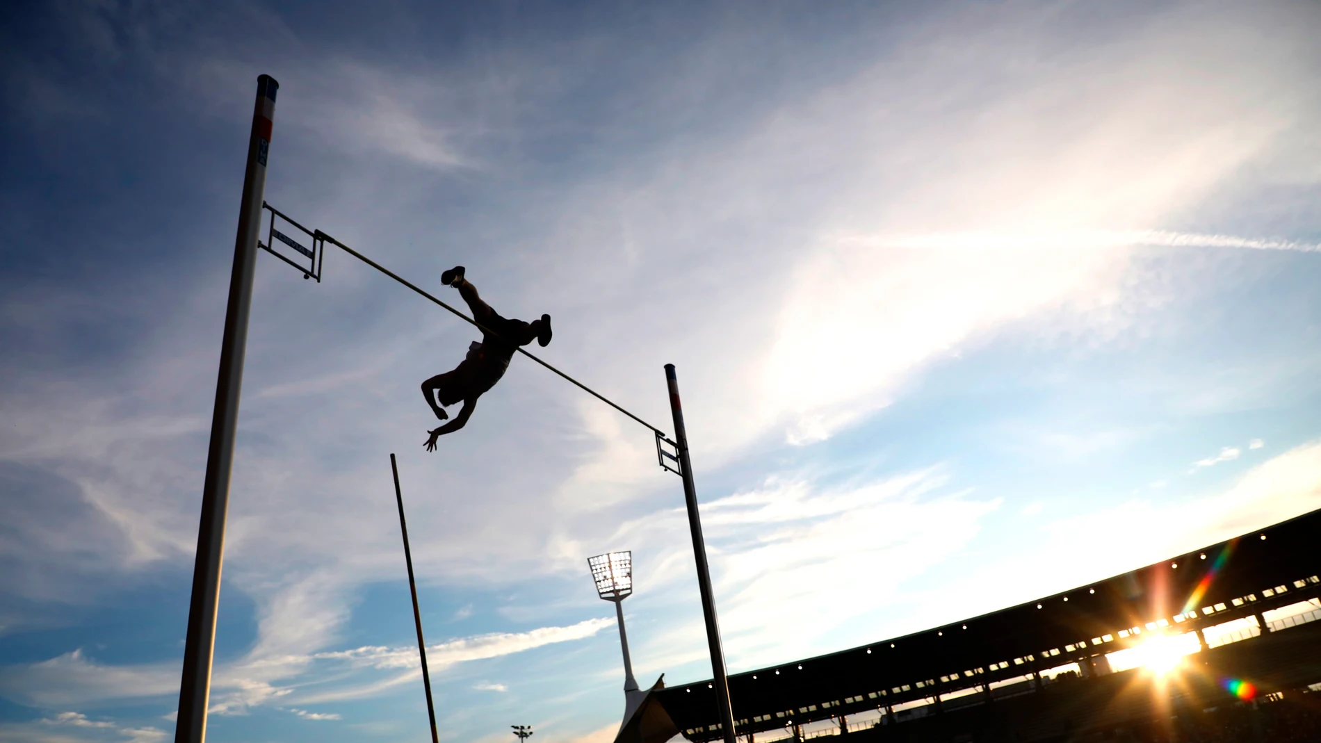 Un saltador de pértiga en pleno salto Un saltador de pértiga en pleno salto