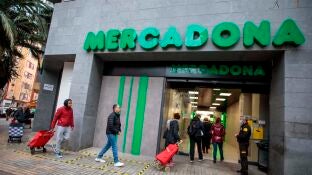 Clientes guardan la distancia de seguridad en la entrada de un Mercadona