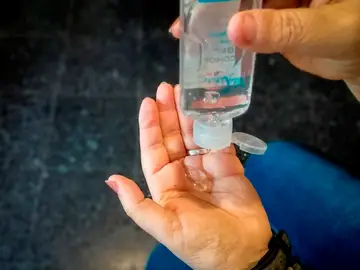 Imagen de una mujer echándose en las manos un gel hidroalcóholico Imagen de una mujer echándose en las manos un gel hidroalcóholico