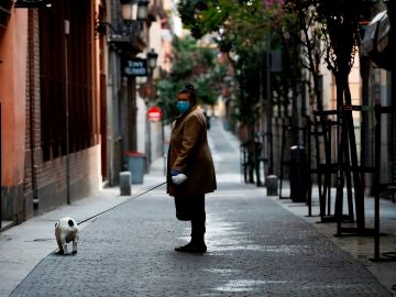 Una mujer pasea a su perro durante la pandemia de coronavirus