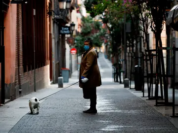 Una mujer pasea a su perro durante la pandemia de coronavirus Una mujer pasea a su perro durante la pandemia de coronavirus