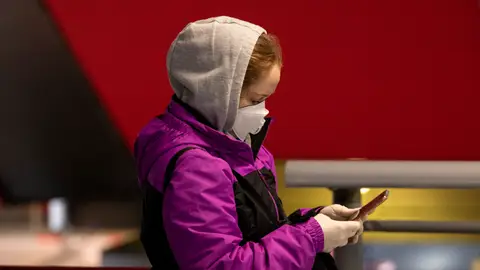 Una ciudadana consulta su teléfono móvil Una ciudadana consulta su teléfono móvil