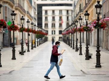 Una persona camina por la calle Larios, en Málaga