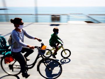 Una mujer con su hijo montando en bici