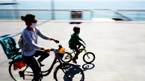 Una mujer con su hijo montando en bici Una mujer con su hijo montando en bici