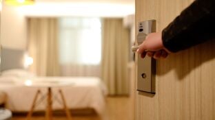 Una persona entra en una habitaci&oacute;n de hotel