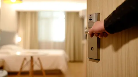 Una persona entra en una habitación de hotel Una persona entra en una habitación de hotel