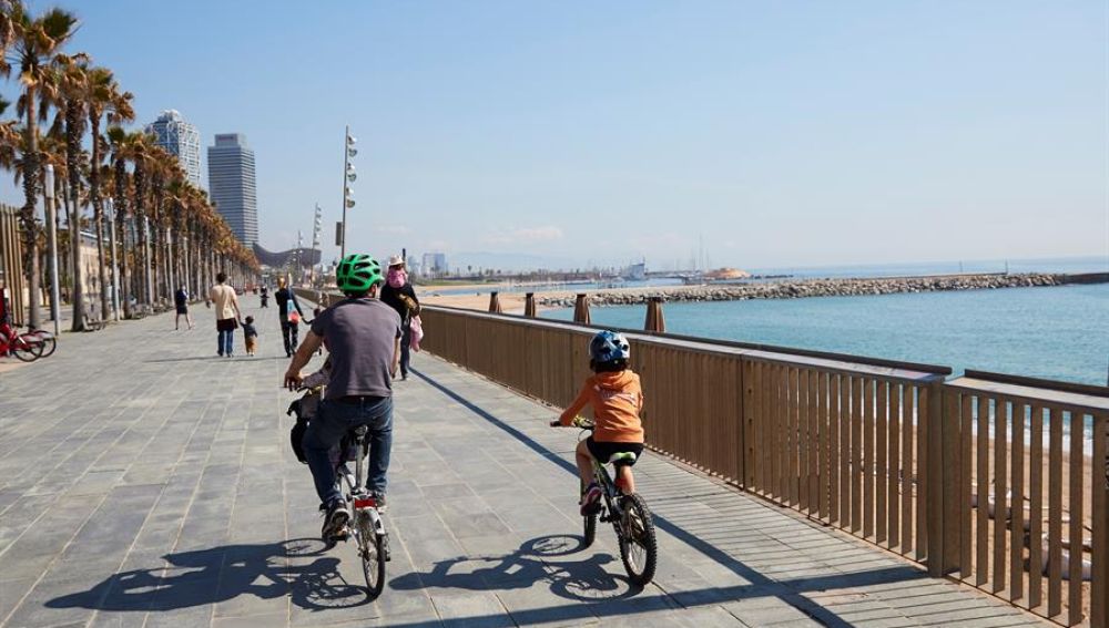 Una familia circula en bici por el paseo marítimo de Barcelona