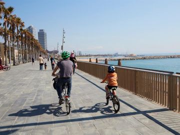 Una familia circula en bici por el paseo marítimo de Barcelona