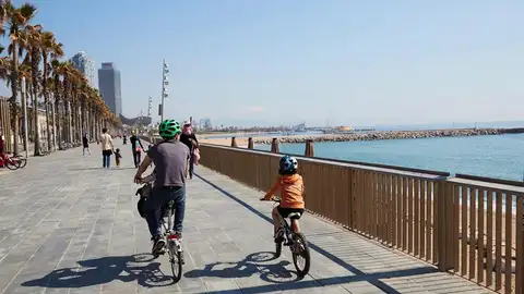 Una familia circula en bici por el paseo marítimo de Barcelona Una familia circula en bici por el paseo marítimo de Barcelona